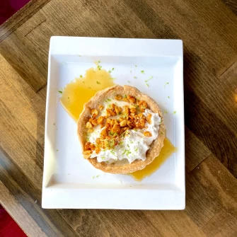 Tart with white chocolate, cajun peanuts and coconut whipped cream